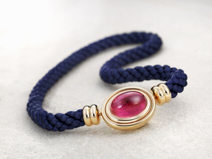 Armband aus blauer Kordel mit goldenem Element mit Stein